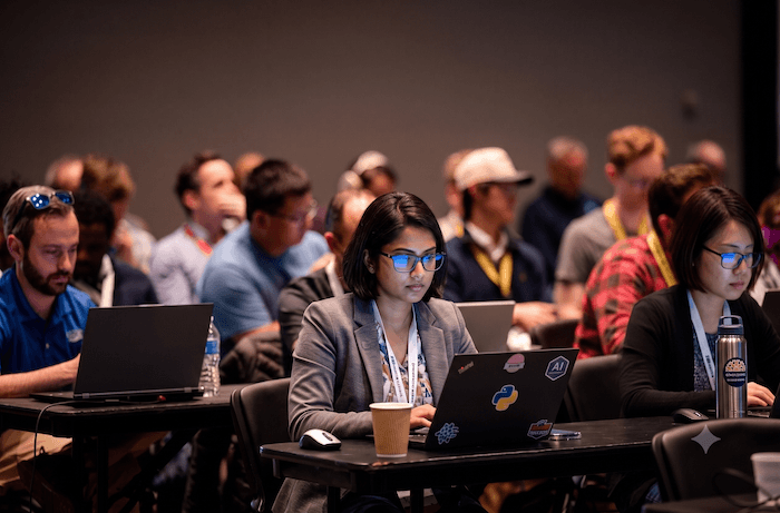 Practitioners working on laptops during an ODSC AI workshop session